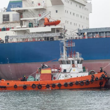 red tugboat assisting large shipred tugboat assisting large ship